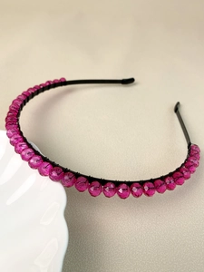 Detail of pink crystal beads hand-wound on a slim black metal festive bridal headband