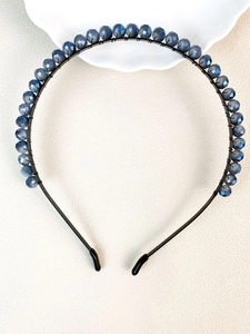 Detail of handcrafted dark blue faceted crystal beads hand-wrapped on a metal headband