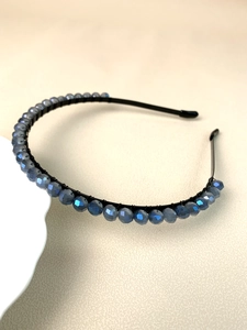 Close-up of blue crystal beads hand-wrapped on a slim black metal headband