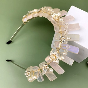 Serre-tête en quartz rose avec perles et fleurs dorées sur un fond minimaliste