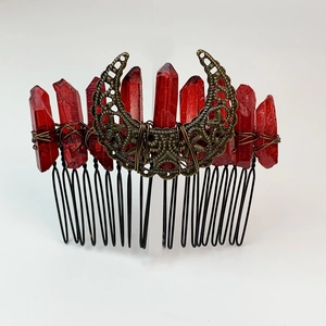 Macro detail of red crystals and crescent moon on bronze gothic hair comb