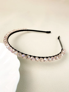 Close-up of champagne crystal beads on a thin black headband for wedding hair accessory