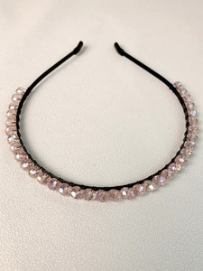 Detail showing hand-beaded champagne crystal beads on a sleek black metal headband