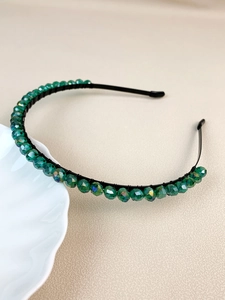 Detailed macro view of emerald green beaded crown headband with intricate wire wrap design