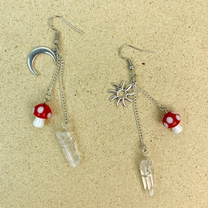 Détail de boucles d'oreilles champignons et cristaux avec pendentifs soleil et lune