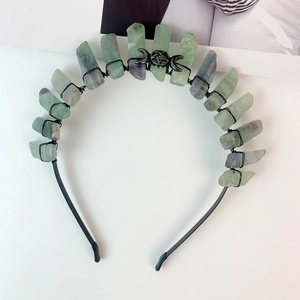 Detail of handmade black crown featuring raw green fluorite and mystical moon symbol