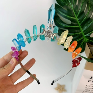 Detail view of colorful crystal crown with silver moon and star ornaments on a wire headband