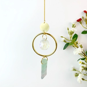 Detailed view of suncatcher featuring a crystal ball and natural fluorite stone pendant
