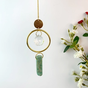 Detail of natural crystal wind chime with faceted glass ball and green amazonite stone