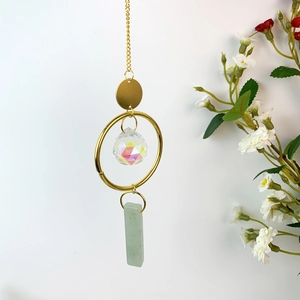 Detail of crystal suncatcher with AB multifaceted ball and light green raw stone pendant