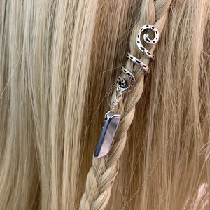 Macro detail of bohemian spiral hair ring with natural grey crystal stone on blonde braid