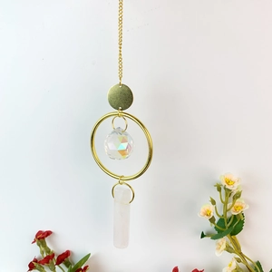 Hanging crystal suncatcher with golden ring, faceted crystal ball and pink raw stone prism