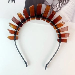 Detailed shot of handmade crescent tiara with raw reddish-brown crystal stones on black band