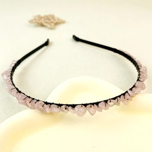 Détail du serre-tête artisanal avec éclats de quartz rose sur support métallique