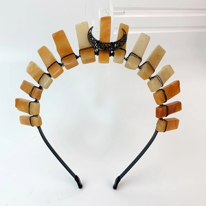 Detailed view of handmade black crescent moon crown with orange raw crystal stones