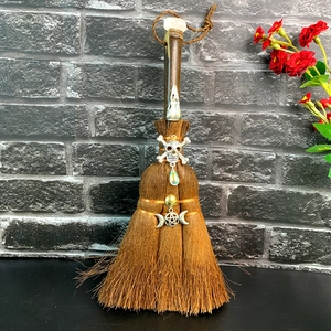 Brown handmade witch broom with natural crystal skull and moon altar decorations