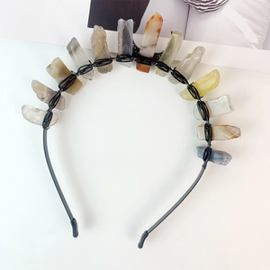 Detail of handmade black crown featuring natural raw crystals in amber and grey hues