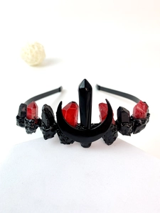 Detailed view of Gothic black moon crown with red crystals and melting wax texture