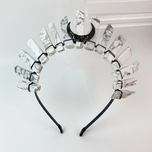 Detail of handcrafted bohemian black metal moon headband with white stone texture