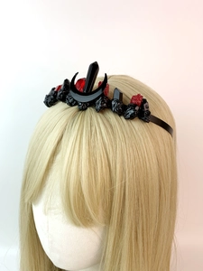 Detailed close-up of gothic crown featuring black crescents and red crystal gemstones