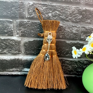 Close-up of wicca mini broom car charm with bird skull pendant and grey crystal drop