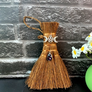 Detail view of mini witch broom car pendant with Wiccan pentagram and purple crystal