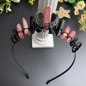 Detail of gothic moon headband with black and orange crystals on a roman column