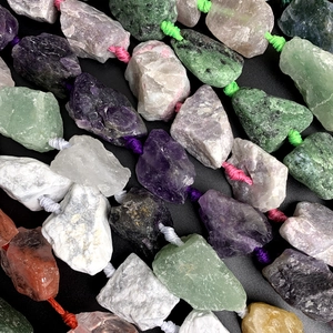 Macro shot of colorful raw natural crystals and gemstones on woven cords detail