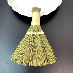 Macro shot of straw broom charm with a bronze witch pendant for festive decoration