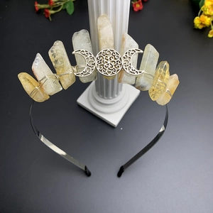 Macro view of raw quartz crystals and Triple Moon symbol wired on a black metal crown