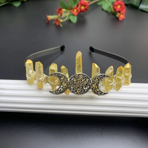 Detail of silver triple moon symbol and raw citrine crystals on black metal headband