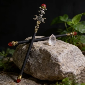 Gothic ritual wand set with crystal, skull and moon symbols on natural stone background