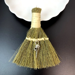Detail view of gothic decorative broom with bird skull pendant and natural straw textures
