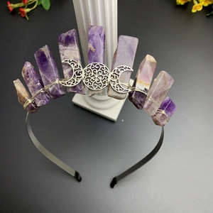 Detailed macro view of purple raw amethyst crystals and silver triple moon goddess on headpiece