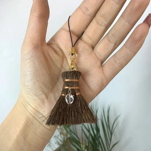 Handmade broom charm with a clear crystal teardrop and golden wire wrap detail