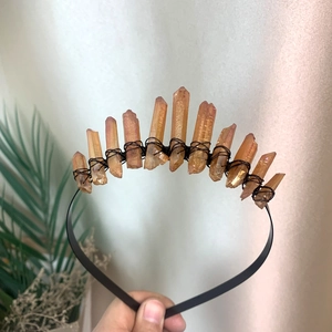 Detail view of handmade orange crystal clusters wire-wrapped on a black moon crown headband