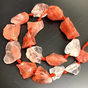 Natural orange crystal stone pendant with red woven cord in a spiral layout