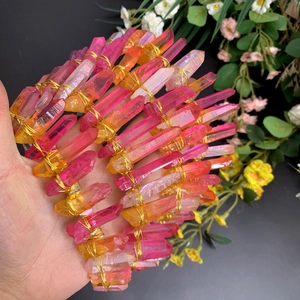Détail de colonnes de cristal dégradé rose et orange sur une couronne de mariée dorée