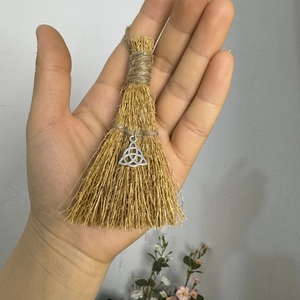 Handmade natural straw witch broom with silver triquetra pendant for holiday decoration
