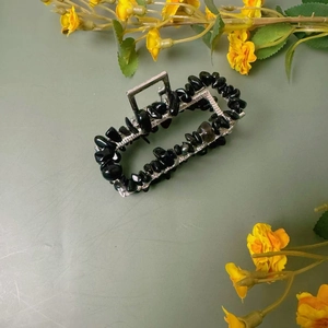 Vue détaillée de la pince à cheveux en métal rectangulaire sertie de pierres noires