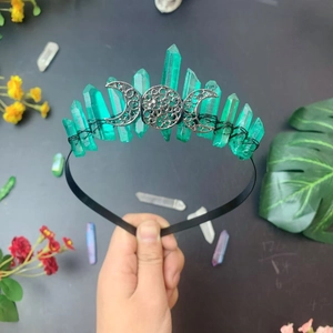 Detailed close-up of handmade Triple Moon crown with green crystals and silver metal charms