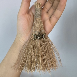 Detail of handmade mini Wicca broom with bronze pentagram and triple moon charm