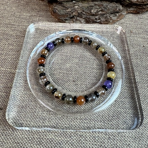 Handcrafted 7mm colorful natural crystal bead bracelet on a minimalist glass tray