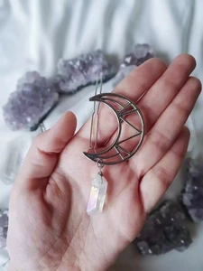 Detail of silver crescent moon hair clip with dangling natural clear crystal point