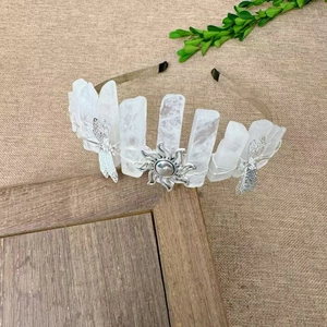 Macro detail of handmade quartz crystal crown with silver dragonfly and sun metal charms