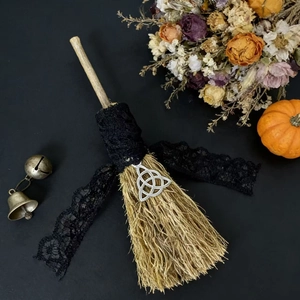 Lace-wrapped straw decorative broom with triquetra pendant and small floral ornaments