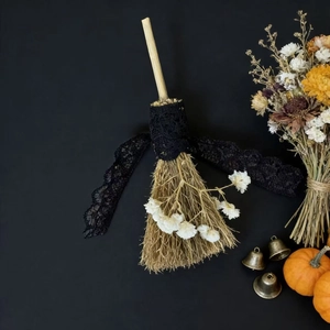 Close-up of lace ribbon and dried flower detail on a handcrafted decorative broom