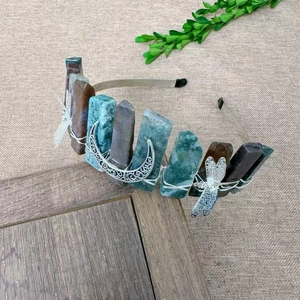 Detail of handcrafted green crystal tiara with dragonfly and moon metal ornaments