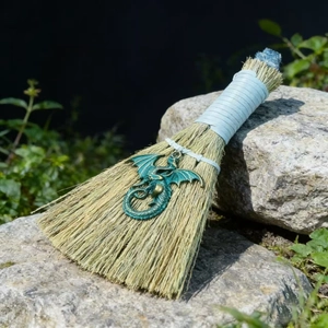 Decorative Halloween witch broom with straw fibers and a vintage bronze dragon pendant