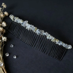 Détail du peigne à cheveux 40 dents fait main avec cristaux bruts sur fond noir élégant